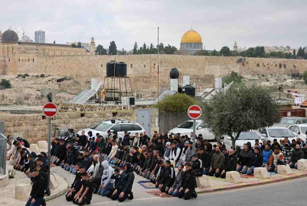 Penduduk Palestin menunaikan solat Jumaat di ruang parkir berhampiran al-Aqsa setelah akses ke masjid itu disekat sejak Perang Gaza tercetus. Foto AFP