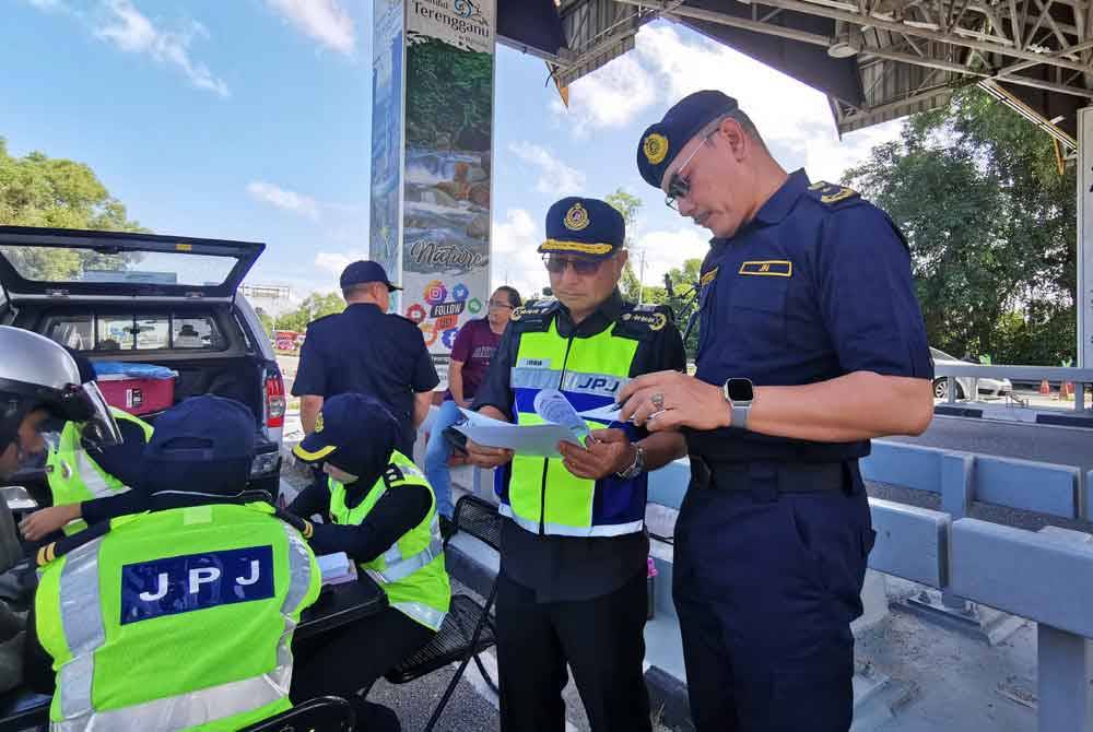 Zulkarnain (kanan) memperincikan Ops Khas Musim Perayaan Tahun Baharu Cina 2024 kepada Lokman ketika sidang akhbar di Kuala Terengganu pada Selasa.