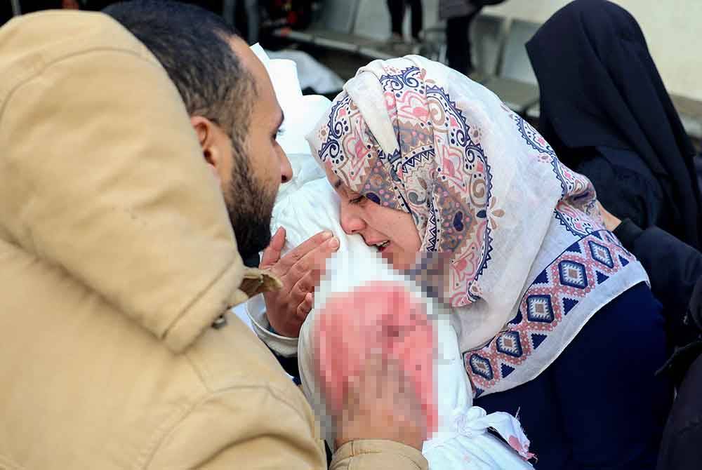 Wanita Palestin merangkul jenazah kanak-kanak di sebuah hospital di Rafah pada Rabu. Foto AFP