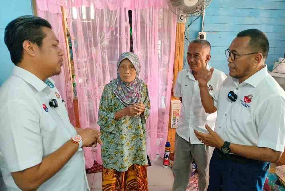 Pandak (kanan) melihat keadaan rumah salah seorang warga emas ketika ziarah kasih di Kampung Pekajang pada Khamis.