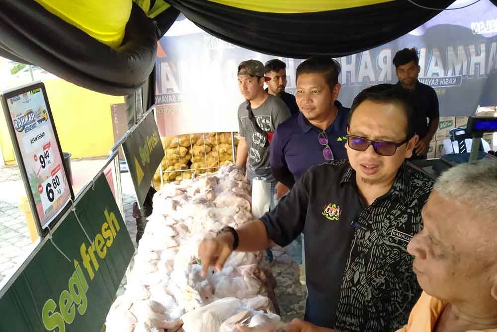 Kamalludin (dua dari kanan) bersama pengunjung melihat ayam segar yang dijual sempena Program Jualan Rahmah Peringkat Negeri Perak Tahun 2024 di Lobi Blok B, Bangunan Persekutuan Greentown di sini pada Jumaat.