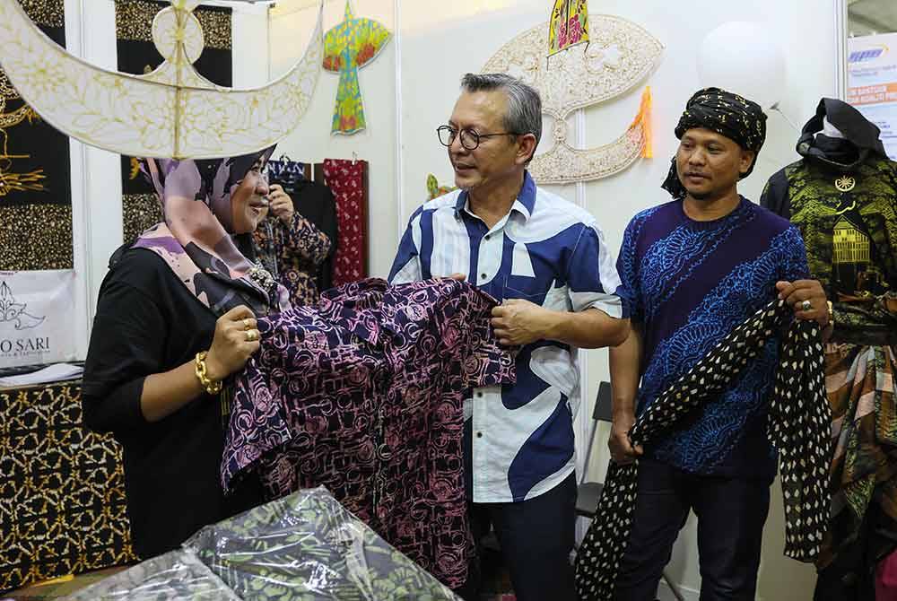 Razali (tengah) melawat reruai jualan baju batik Terengganu pada Karnival Beautiful Terengganu pada Jumaat.