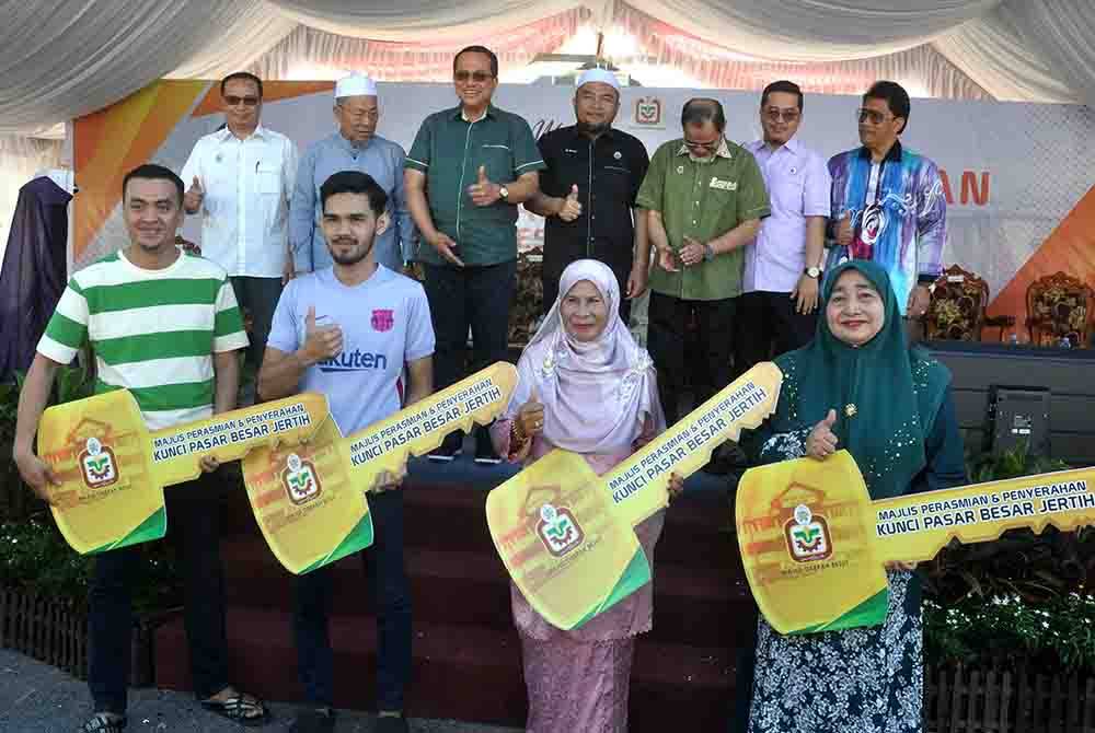 Ahmad Samsuri bersama sebahagian peniaga Pasar Besar Jertih yang menerima replika kunci lot kedai masing-masing pada Majlis Perasmian Pasar Besar Jertih pada Sabtu. Foto Bernama