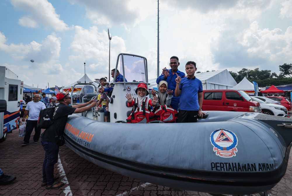 Pengunjung tidak melepaskan peluang menaiki dan bergambar bersama kenderaan aset dari rerurai APM. Foto Bernama