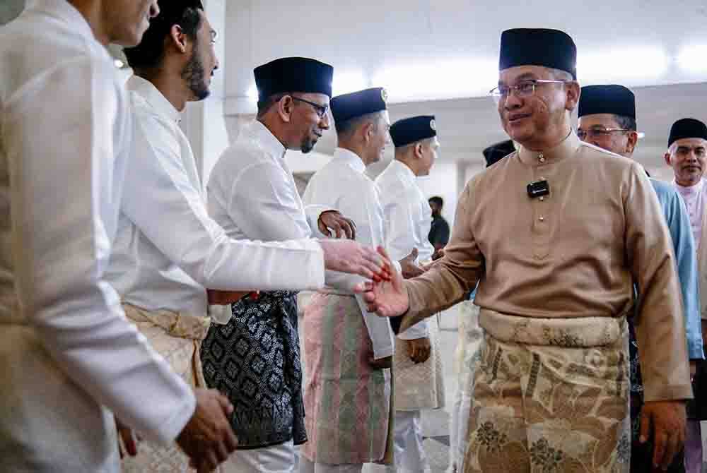 Mohd Na’im (kanan) bersalaman dengan pengantin lelaki yang dinikahkan serentak di Majlis Akad Nikad Rahmah di Dewan Serbaguna Masjid Wilayah Persekutuan, di sini pada Sabtu.