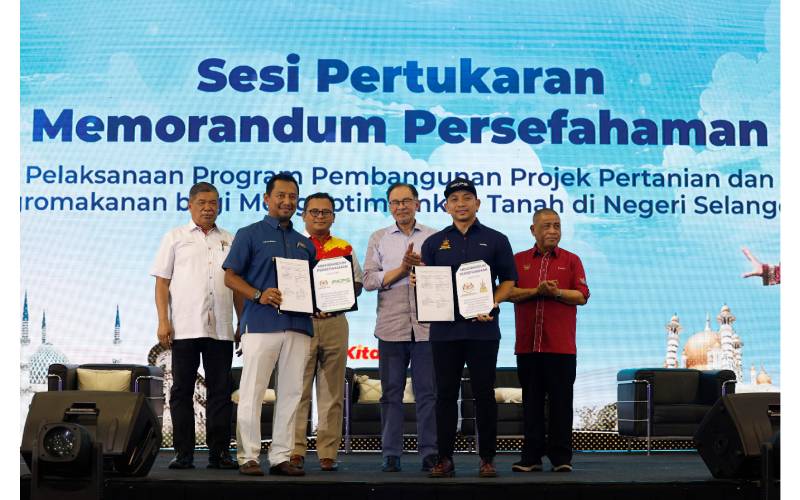 Mohamad Khairil (depan, kanan) dan Lokman Hakim (depan, kiri) masing-masing menunjukkan MoU kerjasama di antara PKPS dengan KPKM sambil disaksikan (belakang, dari kiri), Mohamad, Amirudin, Anwar dan Saarani.