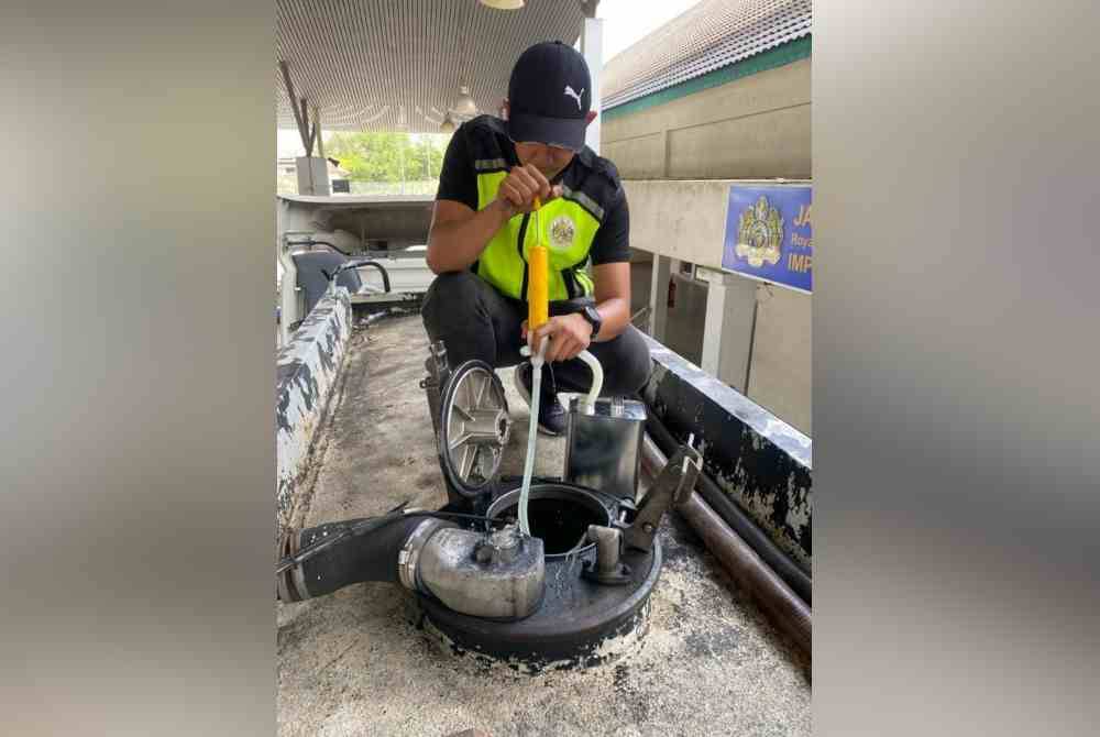 Seorang pegawai kastam Cawangan Penguatkuasaan Durian Burung melakukan pemeriksaan ke atas lori tangki di hadapan pejabat Cawangan Penguatkuasaan Durian Burung, pada 17 Februari lepas.