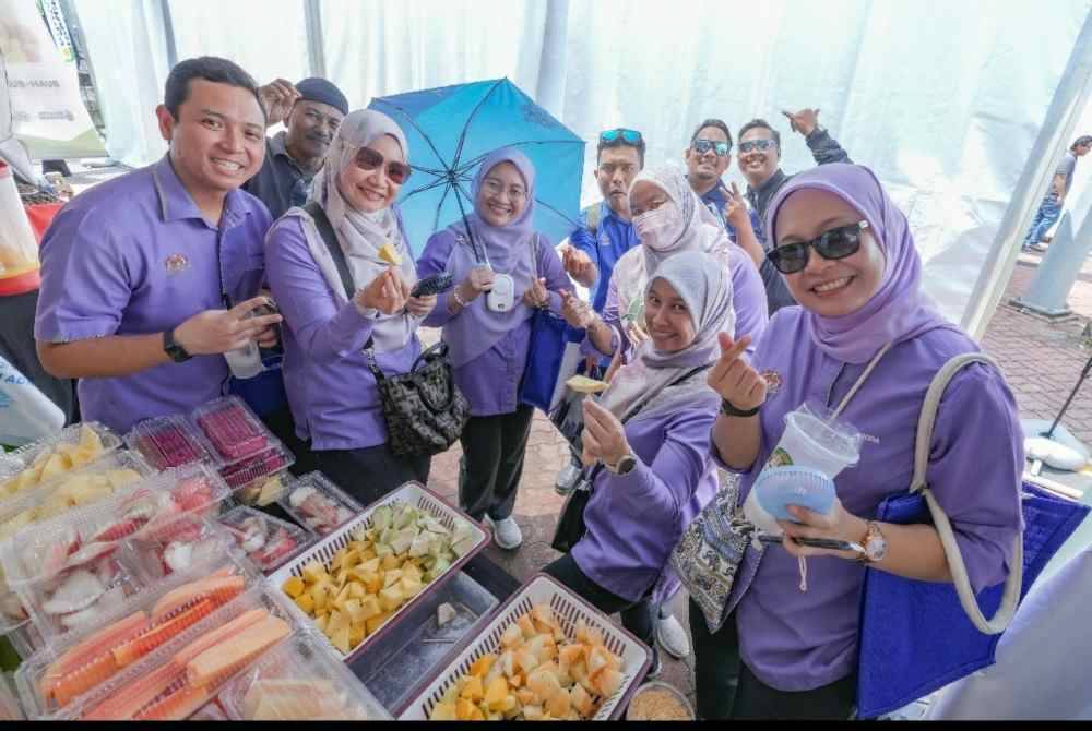 Wakil agensi kerajaan tidak ketinggalan membeli buah potong dari gerai peniaga di PMR Zon Tengah.