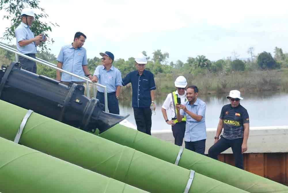 Izham (kanan) melawat Stesen Pam SJAM Rantau Panjang pada Isnin.