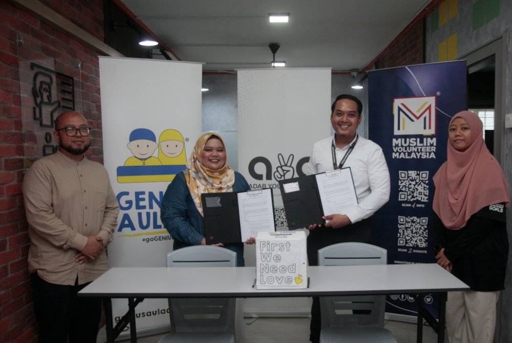 MUHAMMAD HASBULLAH (dua dari kanan) dan Farah Hanisah menunjukkan memorandum persefahaman (MoU) antara MVM dan Genius Aulad bagi menggerakkan kempen mengutip dana membantu kanak-kanak dan remaja daripada keluarga asnaf dan B40. 