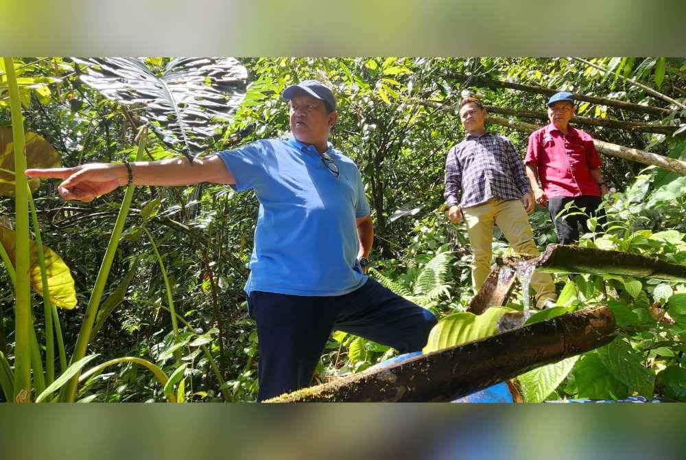 Joniston (kiri) bersama penduduk kampung ketika meninjau sumber air dari mata air bagi mengatasi masalah bekalan air di Kampung Kelawat, Kiulu.