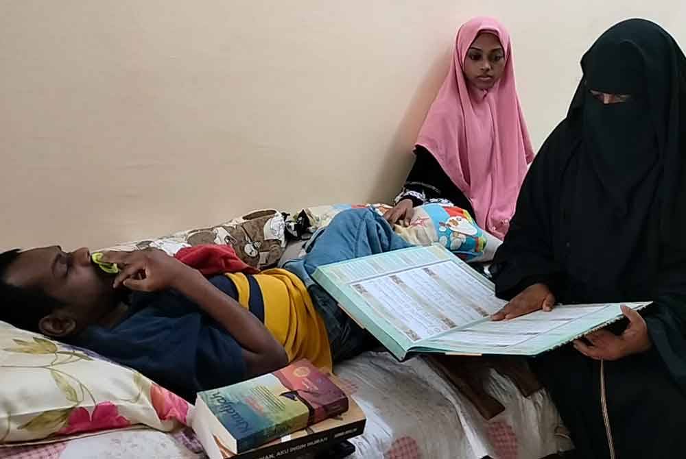 Rahimah sering membace al-Quran ketika menjaga dua anak OKU di rumahnya di Taman Jaya Putra, Johor Bahru.