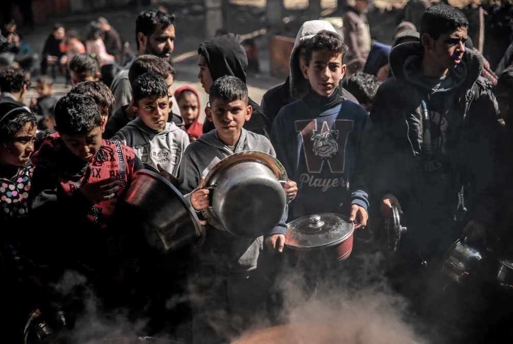 Kanak-kanak Palestin berkumpul untuk menunggu bekalan makanan di Beit Lahia, utara Genting Gaza. AFP