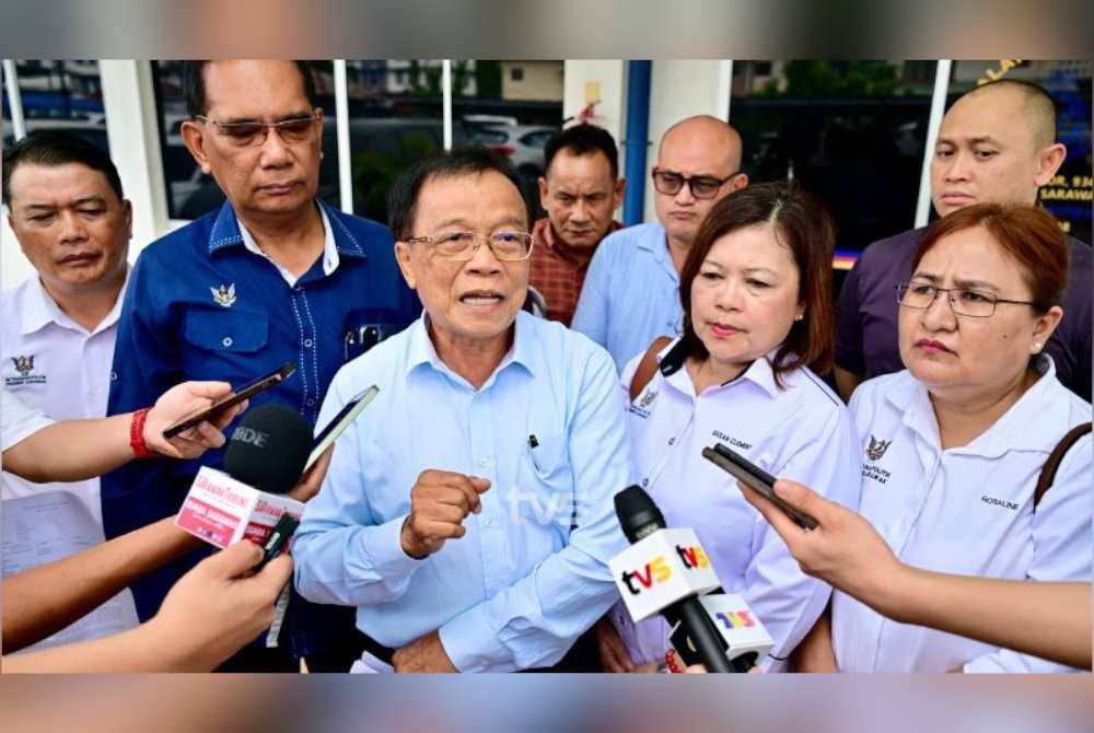 John Nyigor (tengah) bercakap kepada pemberita selepas membuat laporan polis di Balai Polis Satok pada Khamis. Foto TVS