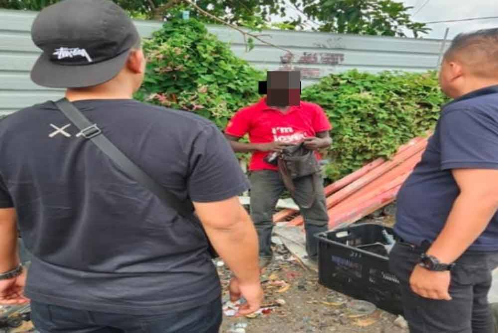 Anggota polis membuat pemeriksaan terhadap suspek.