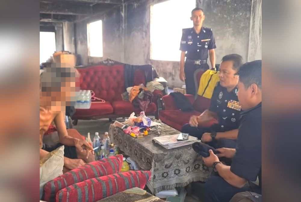 Pesara polis yang tular kerana hidup gelandangan di sebuah premis rumah kedai terbiar di Seremban Jaya, Senawang, di sini, dibantu polis dari IPD Seremban, semalam. Foto Ihsan PDRM