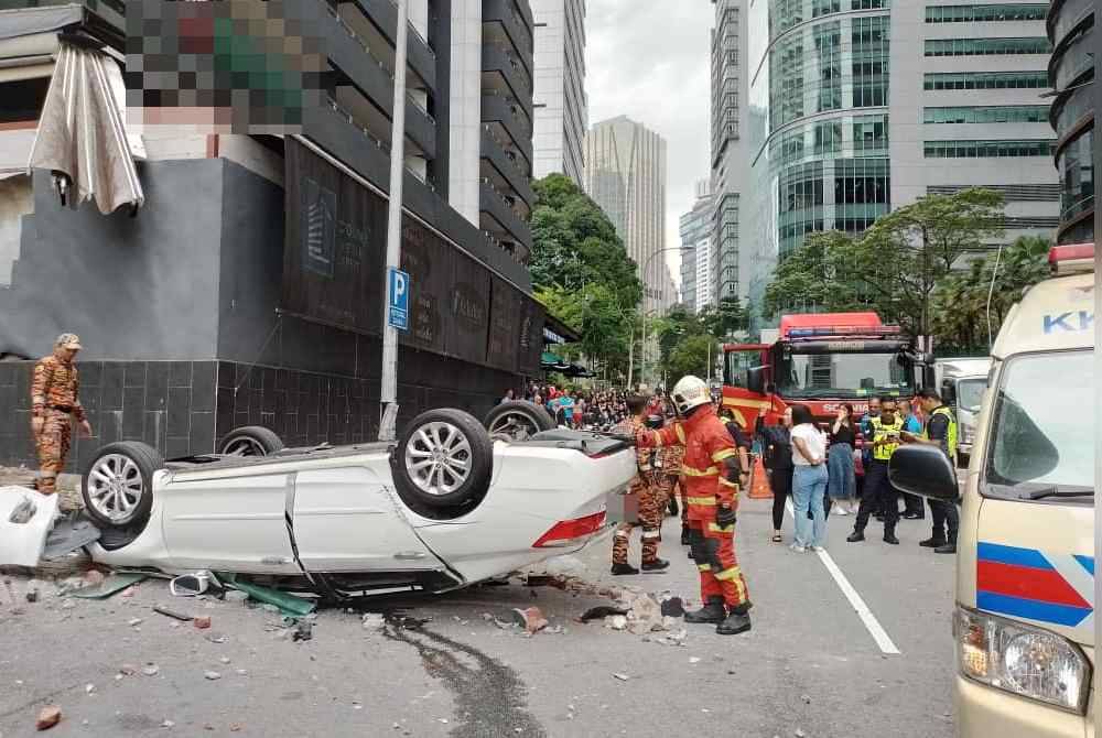 Anggota bomba menjalankan kerja menyelamat mangsa dalam kejadian dekat sebuah bangunan di Jalan P Ramlee di Kuala Lumpur pada Jumaat.