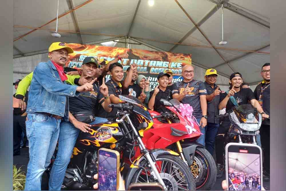 Fadzli (empat dari kanan) bersama pemenang cabutan bertuah pada Program RXZ Fighter Gathering di Serambi Teruntum pada Sabtu.