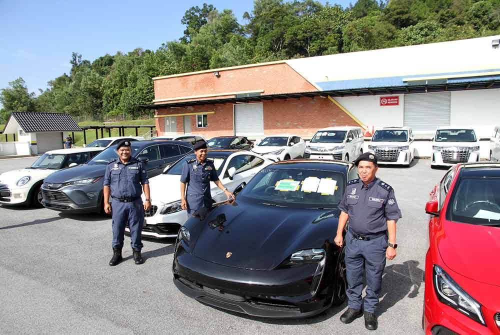 Abdul Ghafar (tengah) menunjukkan sebahagian kereta mewah yang dirampas daripada individu dan syarikat selepas dikesan melanggar syarat pengecualian cukai.