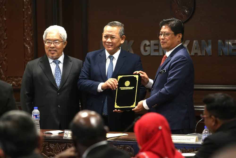 Azam (kanan) menerima dokumen ikrar bebas rasuah yang ditandatangani daripada Aminuddin.