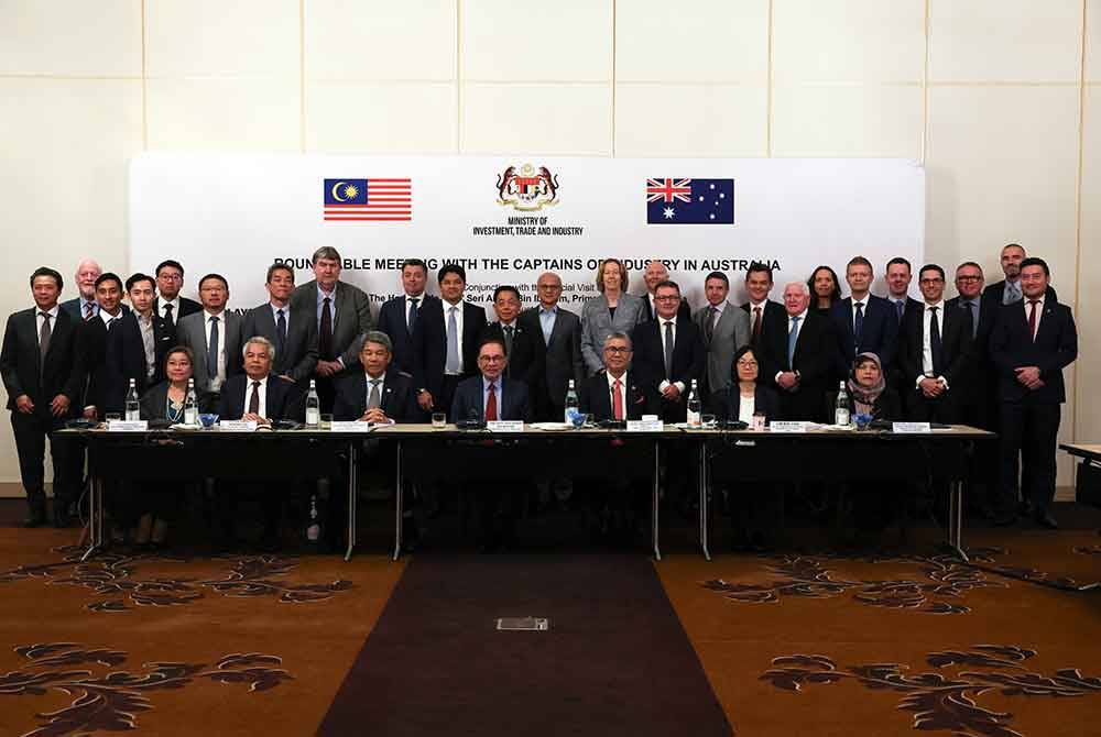 Anwarbergambar bersama wakil syarikat selepas Mesyuarat Meja Bulat dengan pemain industri di Australia. Foto Bernama