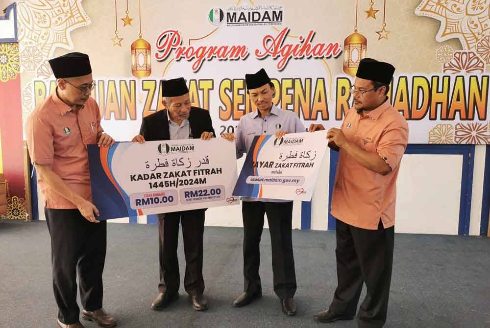 Shaikh Harun (dua dari kiri) menunjukkan dua kadar bayaran zakat fitrah ditetapkan bagi negeri Terengganu pada tahun ini.