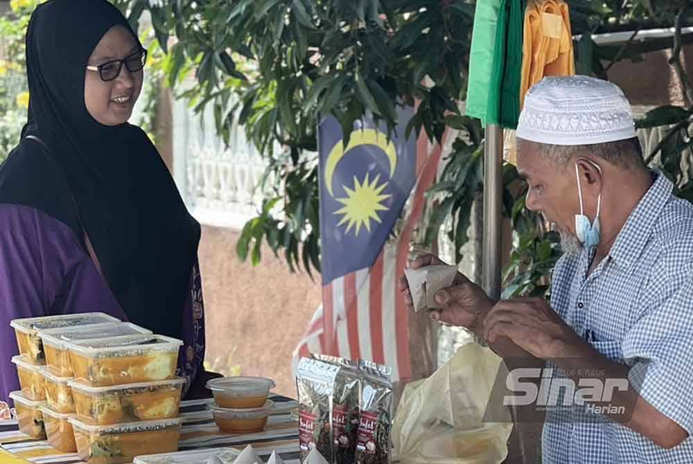 Sabri melayan pelanggan yang ingin mendapatkan ikan patin masak tempoyak yang dijual berdekatan rumahnya di Kampung Telaga Daing, Kuala Nerus.