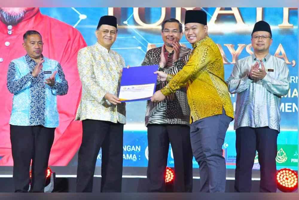 Mohd Arifin (dua dari kiri) ketika menyampaikan sijil kepada peserta Simposium Antarabangsa Turath Sabah di Kota Kinabalu.