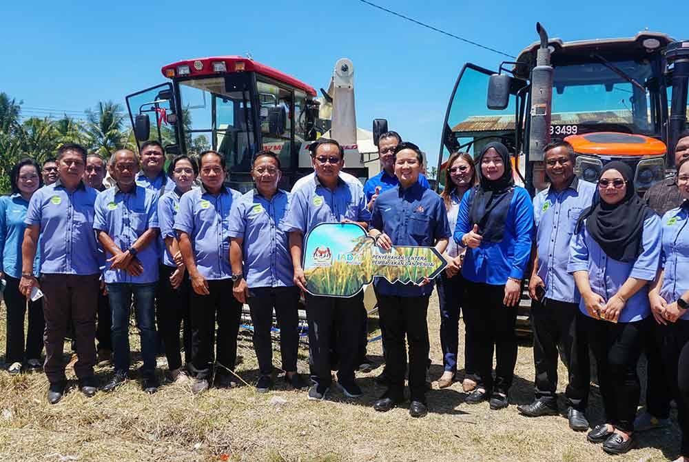 Arthur (empat dari kanan) menyerahkan jentera pembajak dan jentuai padi kepada Koperasi Pesawah Kota Belud.