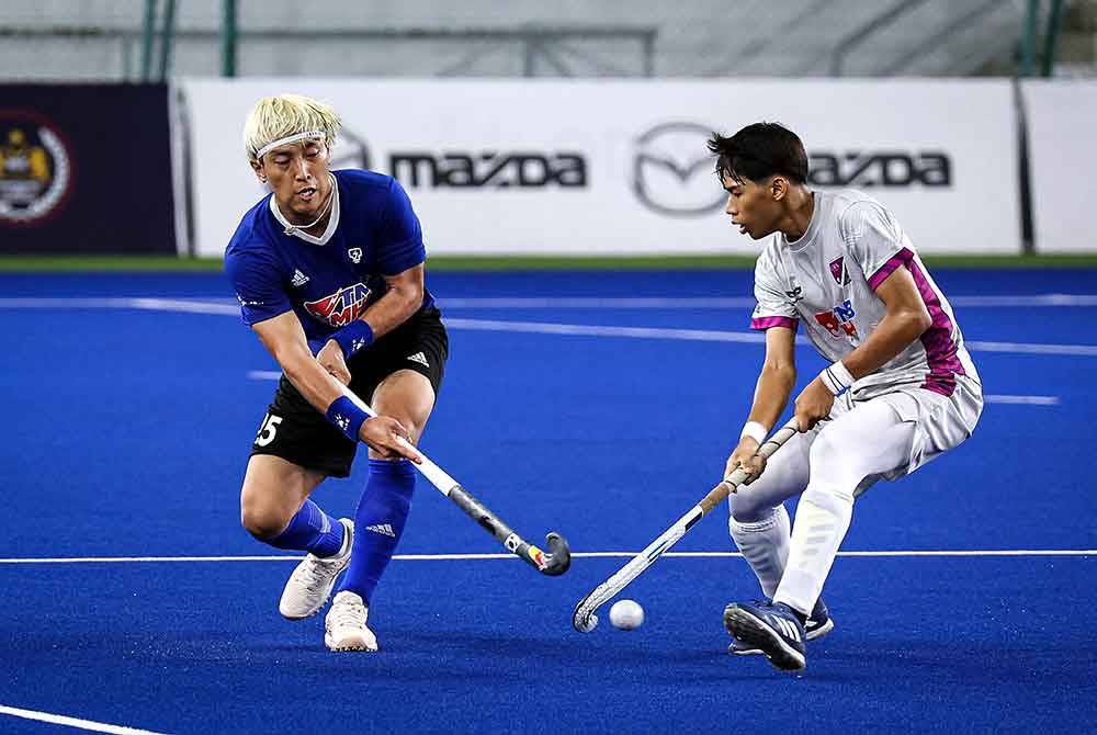 Pemain TNB Jang Jong-hyun (kiri) berentap dengan pemain UITM HA-KPT pada perlawanan separuh akhir kedua Piala TNB di Stadium Hoki Nasional Bukit Jalil pada Khamis.