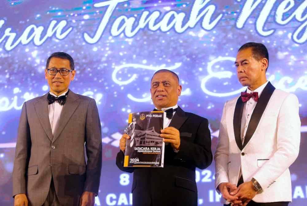 Saarani (tengah) menunjukkan buku Tatacara Kerja Pengurusan Tanah Negeri Perak 2024 pada Majlis Apresiasi Pentadbiran Tanah Negeri Perak di Dewan Galasa malam tadi. Foto Bernama