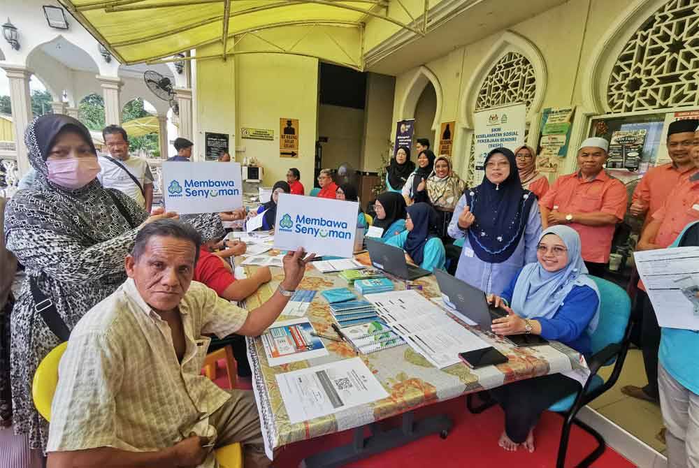 Farihah (dua dari kanan) merakam gambar bersama sebahagian peserta program khidmat komuniti bersama agensi di Masjid Al-Muttaqin, Kepong, Kuala Terengganu.