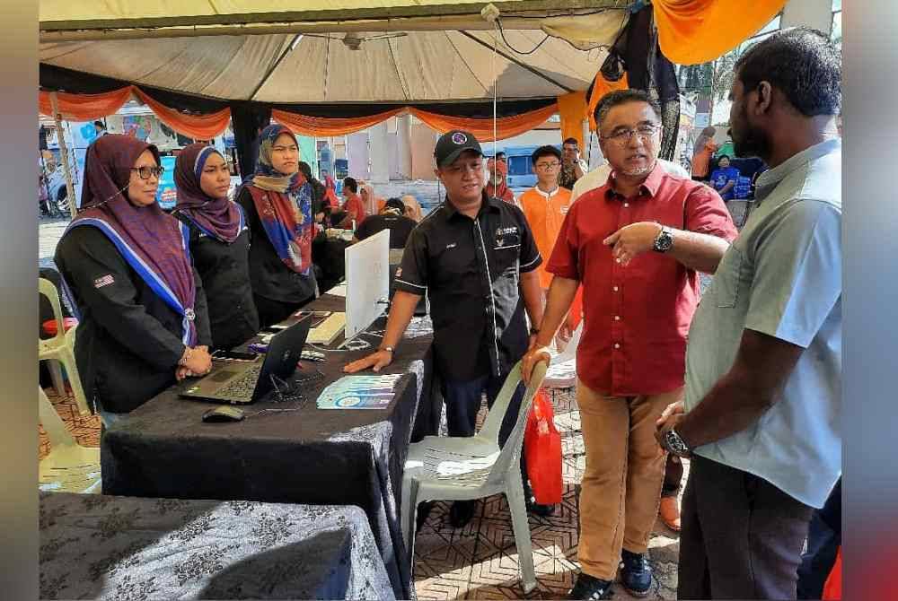 Adly (dua dari kanan) melawat reruai agensi kerajaan pada Karnival Rahmah Parlimen Alor Gajah di Dataran Keris Alor Gajah pada Sabtu.