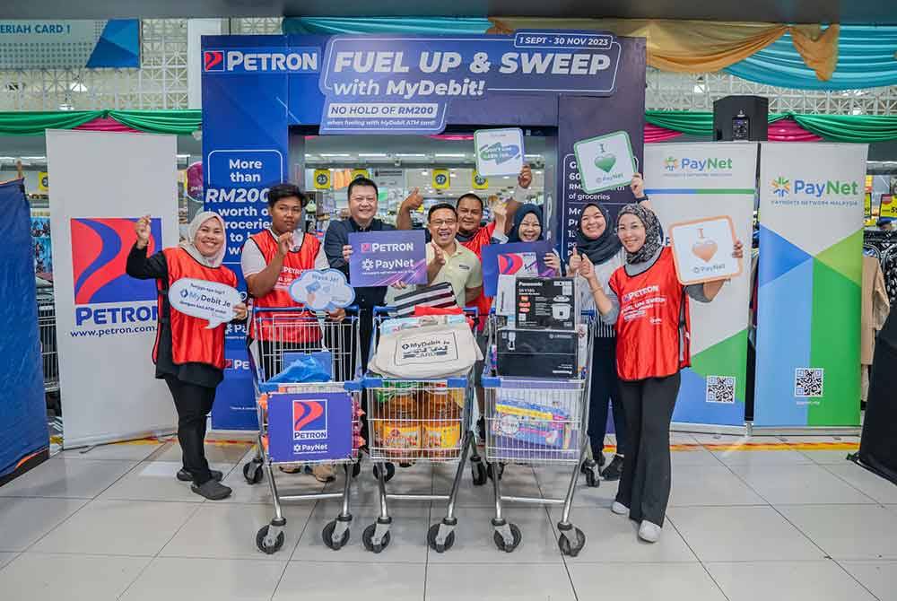 Sebahagian daripada peserta peraduan kempen &#039; ‘Fuel Up and Sweep with MyDebit’di pasar raya terkemuka di sini pada Jumaat. Foto Petron Malaysia.