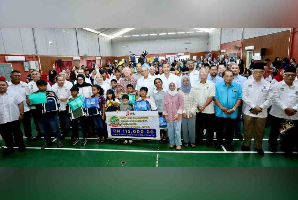 Fadillah (lapan dari kiri) menyampaikan sumbangan bantuan persekolahan di DUN Petra Jaya, Kuching pada Sabtu.