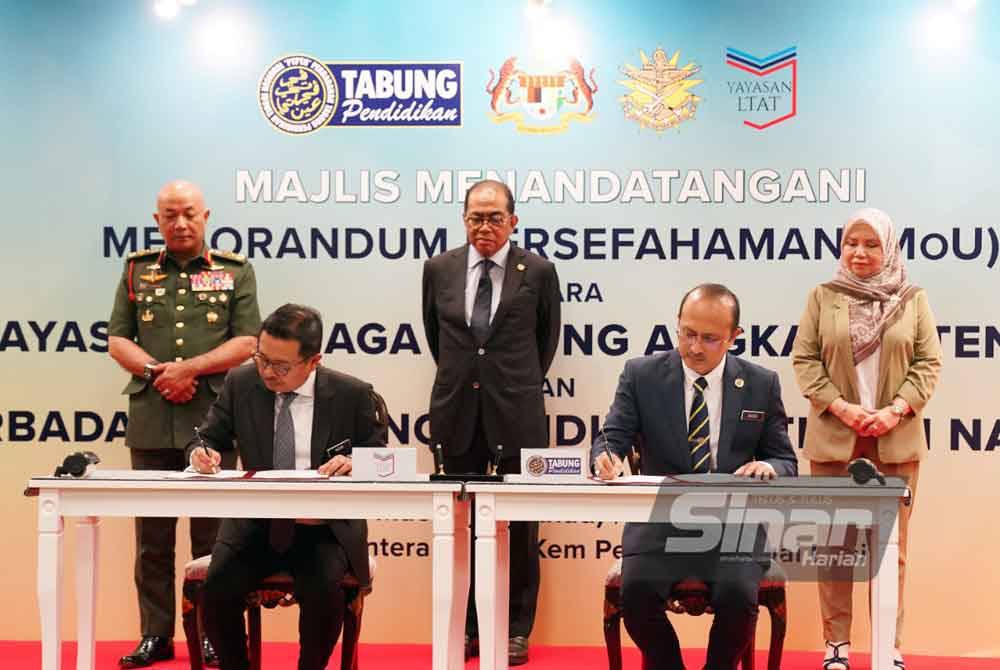 Mohamed Khaled (tengah) melihat proses menandatangani Memorandum Perjanjian Persefahaman (MoU) antara Yayasan LTAT diwakili Ketua Eksekutifnya, Datuk Dr Mohd Nizar Sudin (duduk, kiri) dan Perbadanan Tabung Pendidikan Tinggi Nasional (PTPTN) diwakili Ketua Eksekutifnya, Ahmad Dasuki Abdul Majid pada Pembarisan Tahunan Putera Maktab Tentera Diraja (MTD) yang diadakan pada Ahad. Foto Sinar Harian - ROSLI TALIB