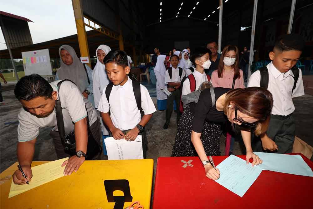 Ibubapa mengiringi anak-anak mereka untuk mendaftar pada hari pertama pembukaan sekolah sesi akademik 2024/2025 di Sekolah Menengah Kebangsaan Sultan Ismail pada Ahad. Foto Bernama