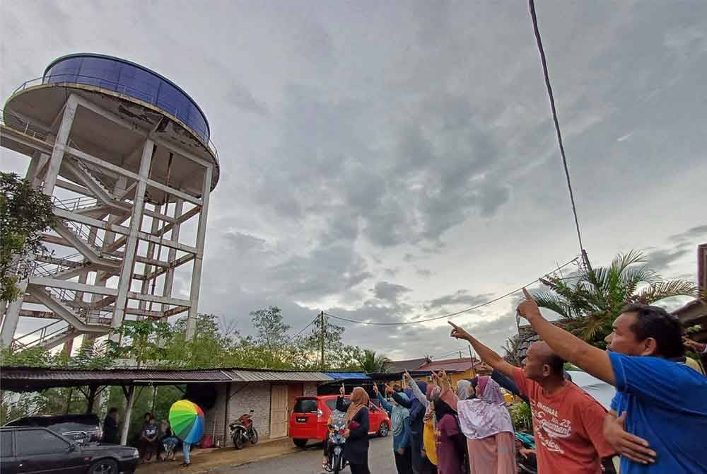 Penduduk menunjukkan tangki air yang berhampiran kawasan perumahan mereka.