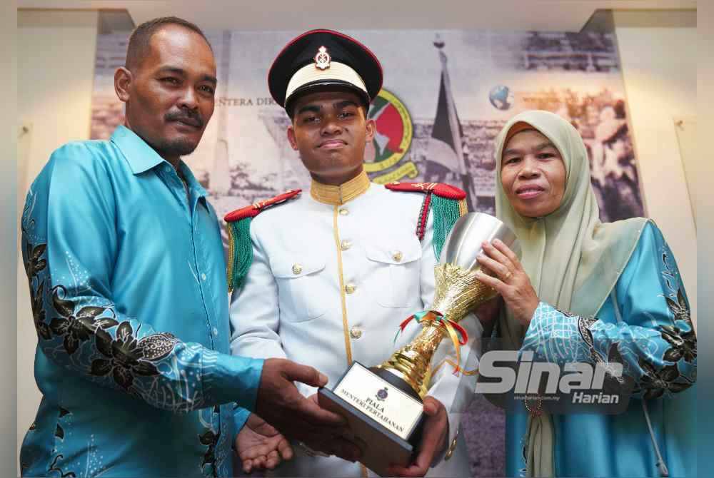 Muhammad Hakimi bergambar bersama ayahnya, Muhamad Higaruddin Hambali dan ibu, Rabitah Md Janis selepas menerima Anugerah Menteri Pertahanan pada majlis Pembarisan Tahunan Putera MTD di Kuala Lumpur pada Ahad. Foto Sinar Harian-ROSLI TALIB