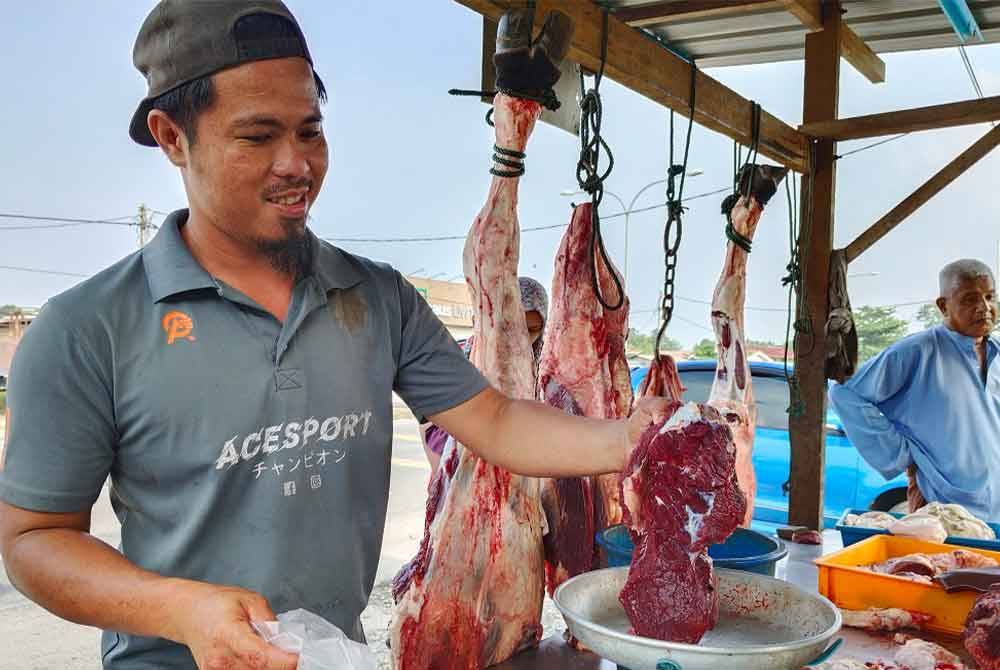 Muhd Shahrulrazi menimbang daging jualannya kepada pelanggan yang singgah berbelanja di gerainya di Kampung Chica. - Foto: Bernama