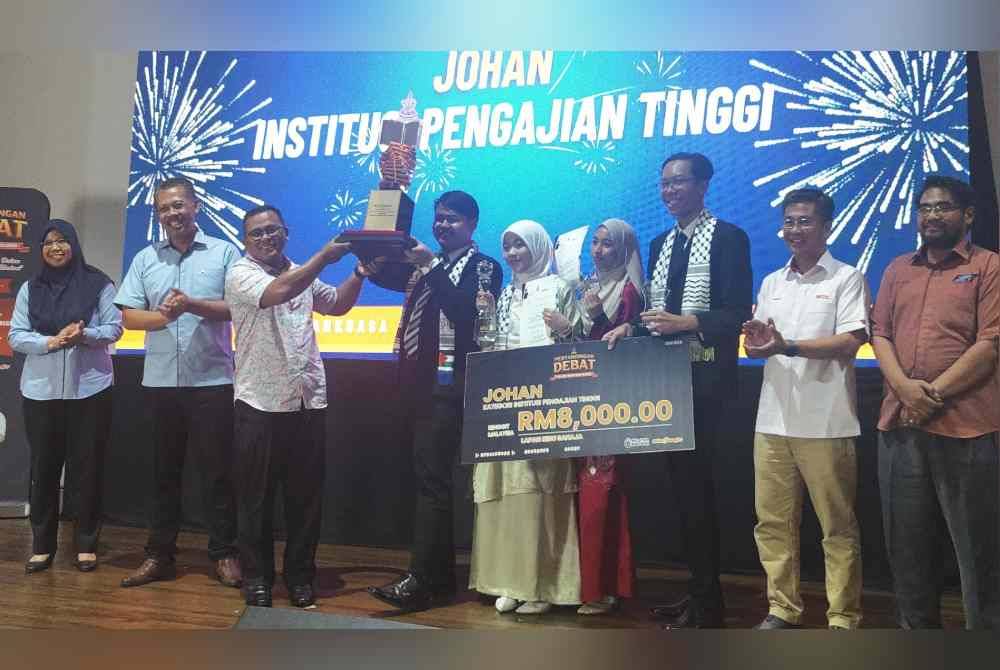 Amirudin (tiga dari kiri) menyampaikan hadiah kemenangan kepada pendebat USIM pada Pusingan Debat Piala Dato&#039; Menteri Besar Selangor di STDC pada Ahad.