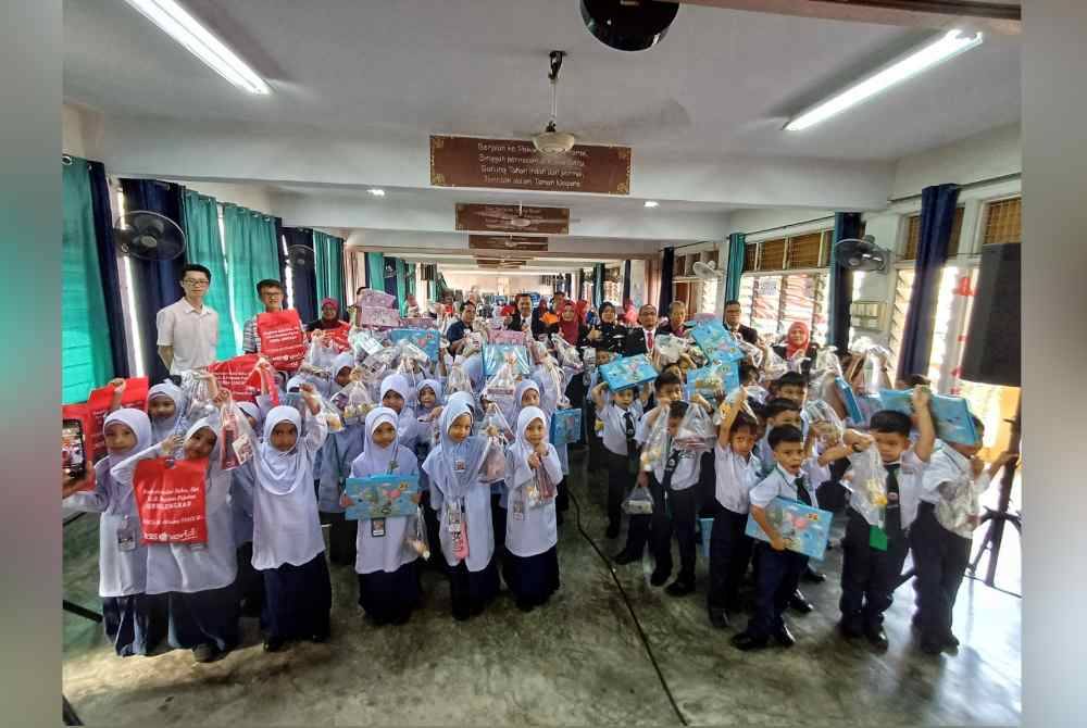 Azman (berdiri, lima dari kiri) bersama murid tahun satu SK Indera Mahkota Utama pada Isnin.