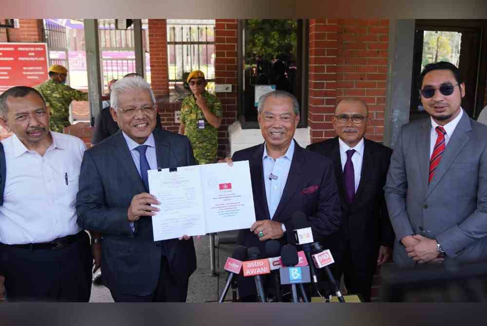 Muhyiddin bersama pimpinan tertinggi menunjukkan dokumen Pindaan Perlembagaan Bersatu pada sidang media di Putrajaya pada Isnin.