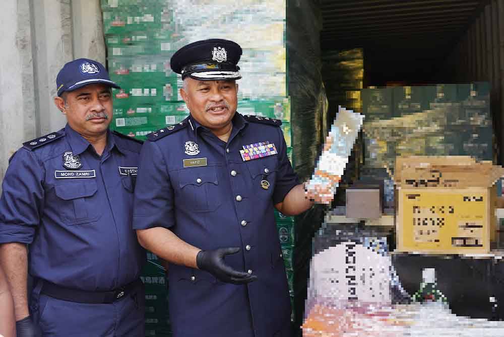 Mohammad Hafiz menunjukkan minuman keras yang dirampas ketika mengadakan sidang media mengenai dua sindiket pengedaran rokok putih dan minuman keras bernilai lebih RM13 juta di Pejabat Kastam Negeri Sembilan. Foto Bernama