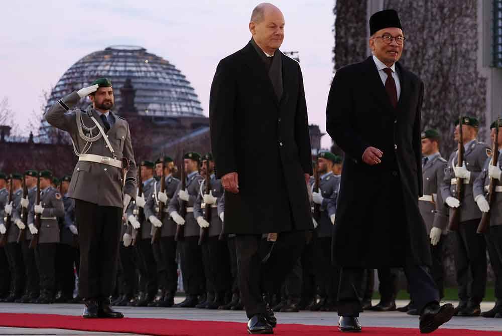 Anwar (kanan) bersama Canselor Jerman Olaf Scholz memeriksa barisan kawalan kehormat Tentera Jerman pada Majlis Sambutan Rasmi bersempena dengan lawatan rasmi enam hari beliau di Federal Chancellery pada Selasa.