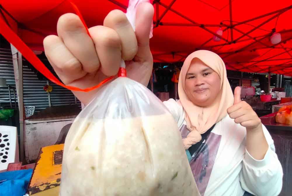 Mastura menunjukkan bubur lambuk yang dijual pada harga RM3.50