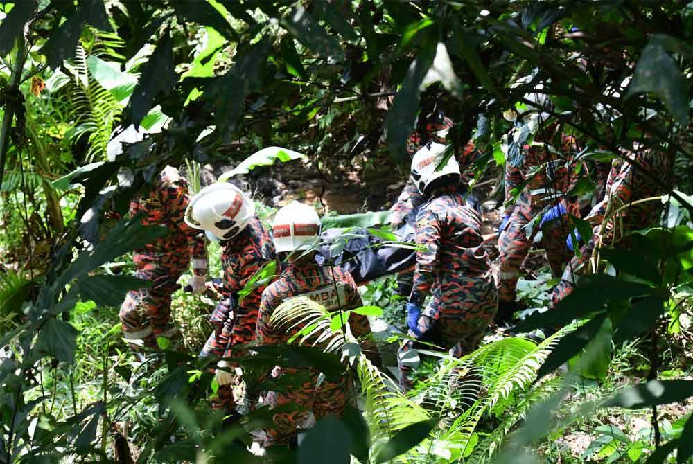 Anggota bomba membawa mayat mangsa untuk naik ke atas dari gaung di Jalan Paya Terubong.