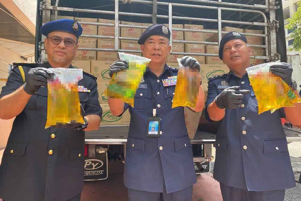 Wan Jamal Abdul Saman (tengah) menunjukkan minyak masak bersubsidi yang berjaya dirampas.