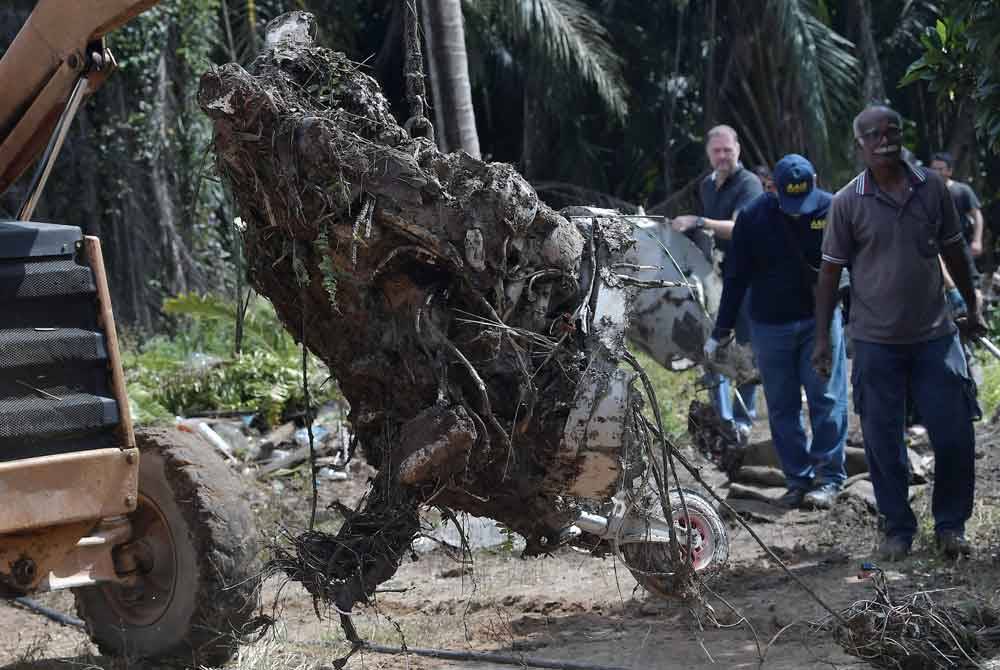 Anggota Biro Siasatan Kemalangan Udara mengangkat keluar enjin pesawat ringan model BK 160 Gabriel yang terhempas di Kampung Tok Muda di Kapar. Foto Bernama