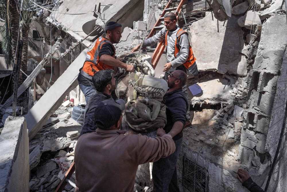 Pasukan penyelamat mengeluarkan mayat penduduk Palestin dari runtuhan rumah mereka selepas serangan Israel di Deir el-Balah di tengah Semenanjung Gaza pada Rabu. Foto AFP